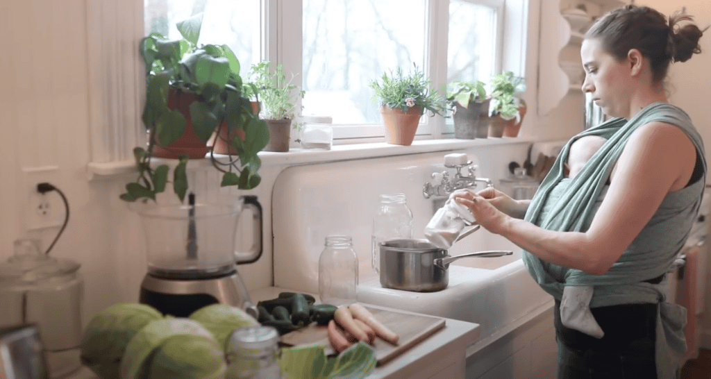 Woman adding salt into a small saucepan. 
